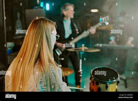 Rear View Of Unrecognizable Woman With Long Hair Playing Drums On Stage