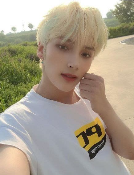 A Man With Blonde Hair Wearing A White T Shirt And Posing For The Camera