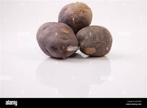 Purple Vitelotte Potatoes Isolated Over White Background Stock Photo