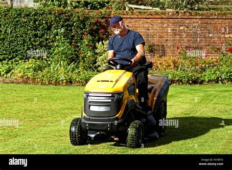 Grass Cutter In The Work Machine For Cutting Lawn Is Standing Outdoors Summer Bright Photo Stock