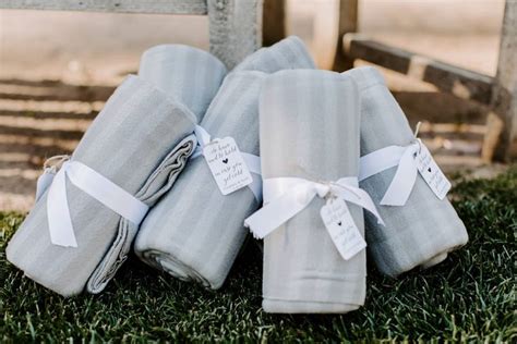 Several Folded Gray Towels On The Grass With White Ribbons And Tags