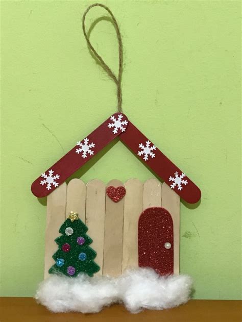 A Christmas Decoration Made Out Of Popsicle Sticks With A House And