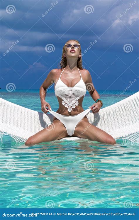 Elegant Woman In The White Bikini On The Sun Tanned Slim And Shapely