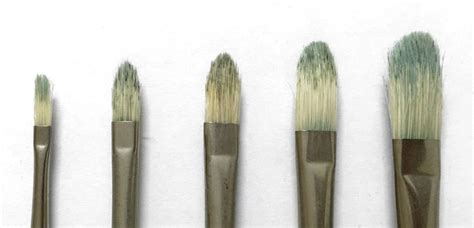 Five Brushes Are Lined Up On A White Surface