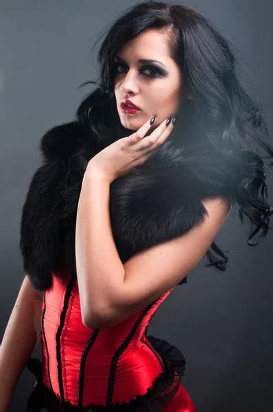 Sexy Brunette In Red Corset Fur And Long Hair In Studio Stock Photo FlexDreams