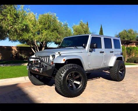 A Silver Jeep Parked In Front Of A House