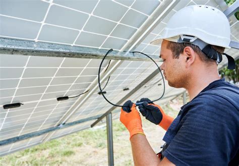 Soltekniker Monterar Solcellspaneler Fotografering för Bildbyråer