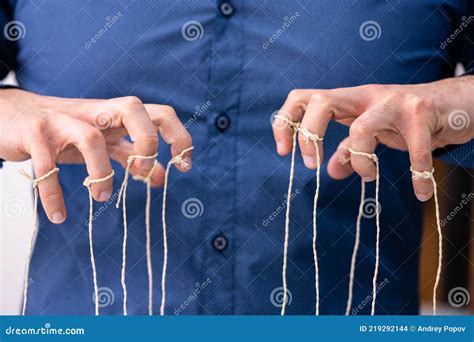 manipulating marionette puppet strings  hand stock photo image