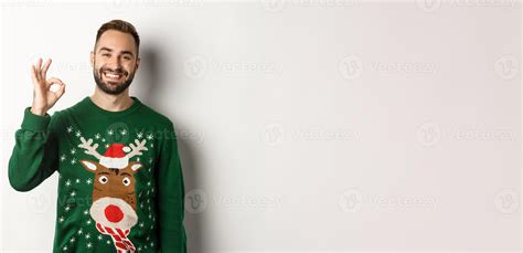 Winter holidays and christmas. Happy bearded man showing okay sign and
