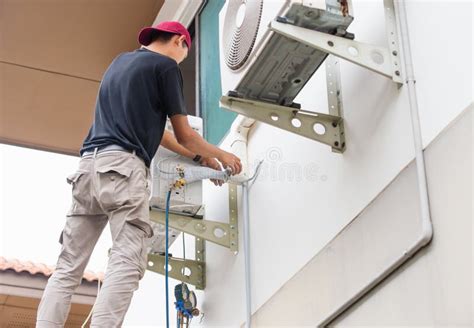 Air Conditioning Repairman Checking And Fixing Modern Air Conditioning