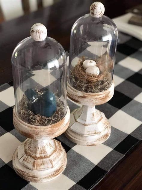 Two Glass Domes Sitting On Top Of A Checkerboard Tablecloth Covered