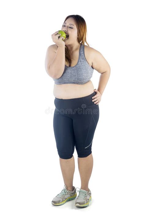 Mujer Obesa Que Come Una Manzana En Estudio Imagen De Archivo Imagen