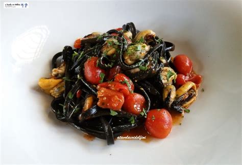 Tagliolini al nero di seppia con cozze tarantine e pomodori datterino ...