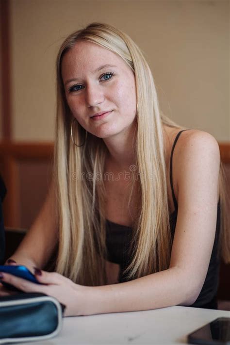 High School Blonde Student Using Her Smartphone To Connect With Friends