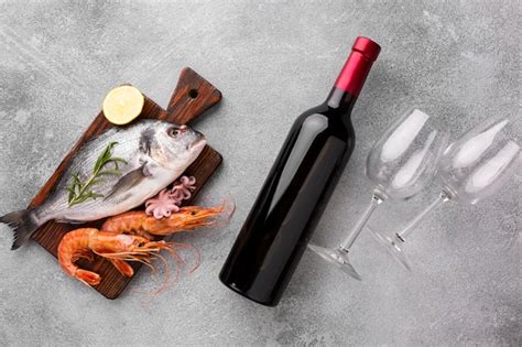 Free Photo | Top view fresh fish and bottle of wine