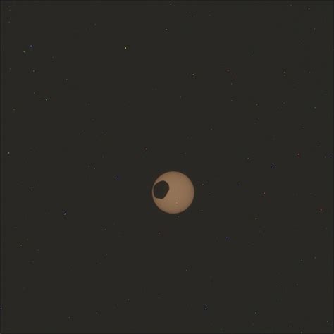 Solar eclipse on Mars shows the planet partially covered in darkness in ...