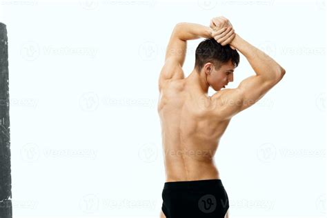Sporty Man With Naked Body And In Shorts Holding His Hands Above His Head Back View