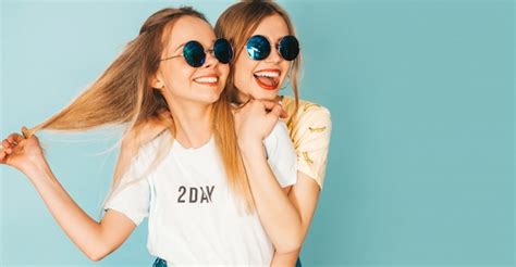 Zwei junge schöne lächelnde blonde Hippie Mädchen im bunten T Shirt des