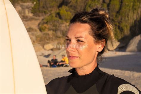 Female Surfer Carrying Surfboard On Beach Head And Shoulder Cape Town