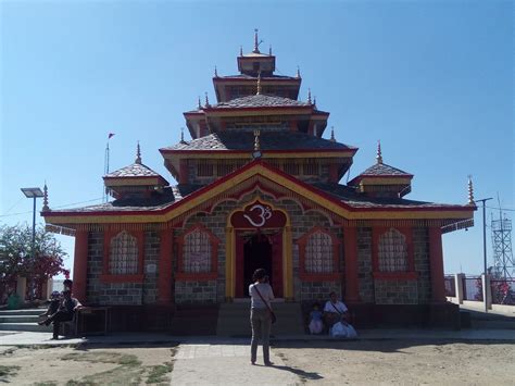 a man standing in front of a red and yellow building