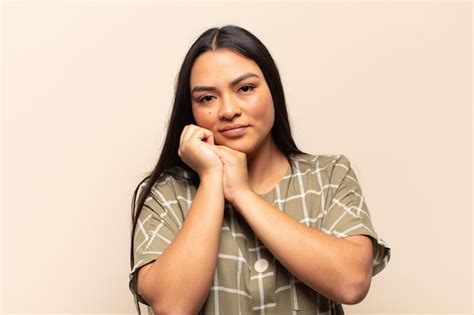 Joven latina que se siente enamorada y se ve linda adorable y feliz sonriendo románticamente