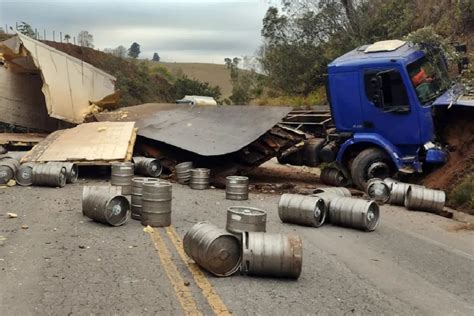 Caminhão carregado chope tomba e lança barris a bebida na pista