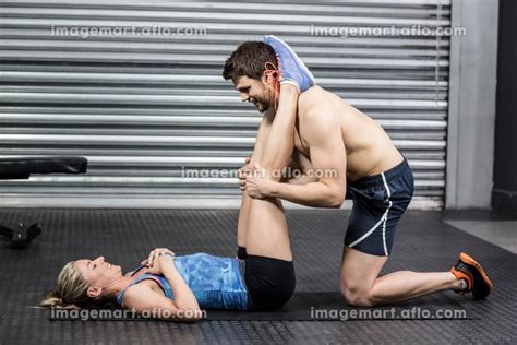 Male Trainer Assisting Woman With Sit Ups