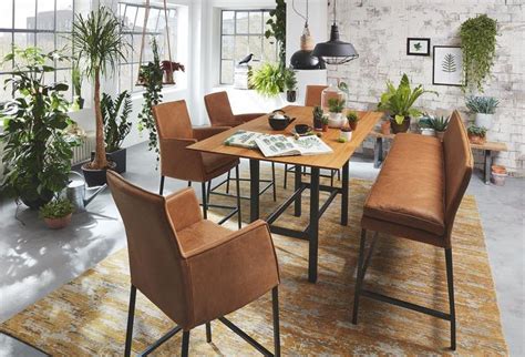 A Dining Room Table Surrounded By Chairs And Potted Plants