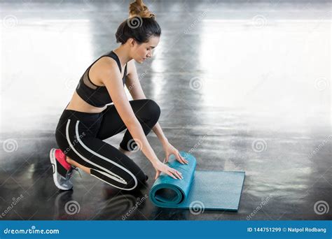 Fitness Young Asian Woman Rolling Blue Yoga Mat After Workout In Gym