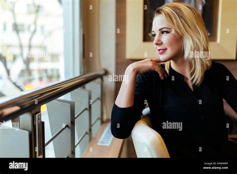 Blonde Unternehmerin Schaut Aus Dem Fenster Stockfotografie Alamy
