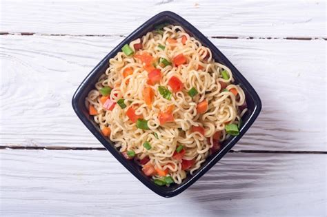 Premium Photo Instant Noodles In Bowl With Carrot Tomatoes And Onion