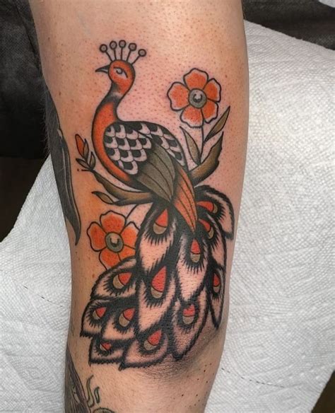 a colorful peacock tattoo on the leg