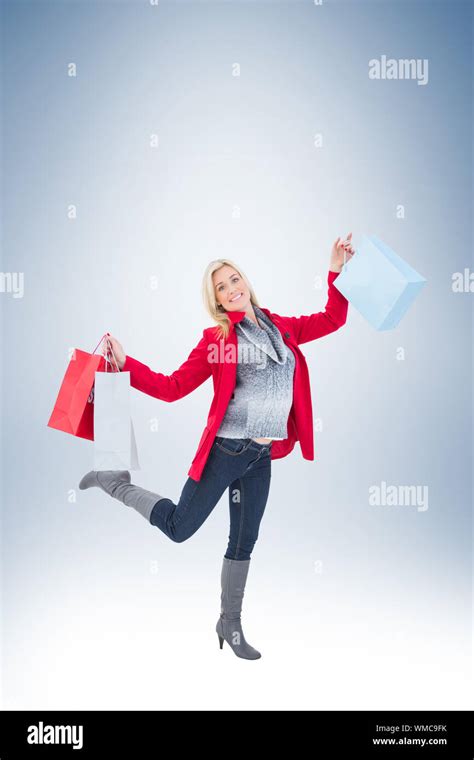 Happy Blonde In Winter Clothes Holding Shopping Bags On Vignette