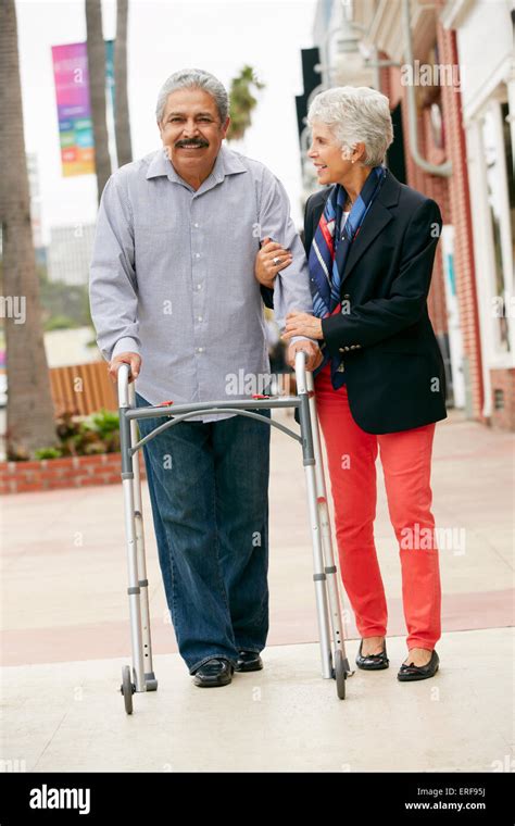 Wife Helping Senior Husband To Use Walking Frame Stock Photo Alamy