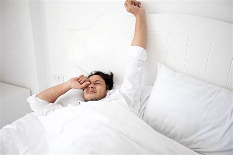 Um Homem Acordando Em Sua Cama Totalmente Descansado E Abrindo As