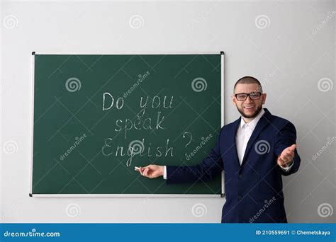 Teacher Near Green Chalkboard With Words Do You Speak English Stock