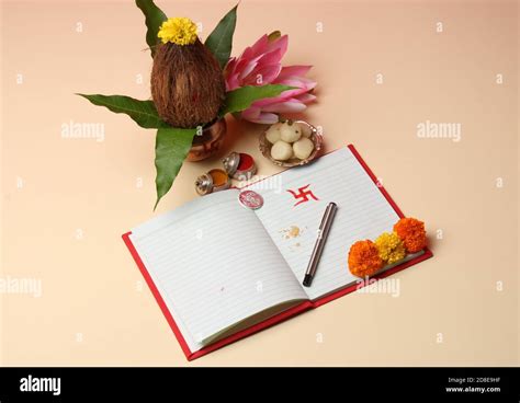 Red accounting note book / bahi khata with copper kalash, sweets, marigold, haldi kumkum, pen ...