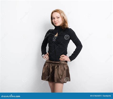 La Belle Jeune Blonde Aux Longues Jambes Dans Un Chemisier Noir Et Une Jupe Brune A Mis Ses