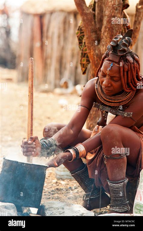 Himba Woman Cooking Food Based On Maize Meal In His Village Near Epupa