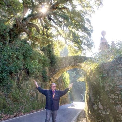 A Man Standing On The Side Of A Road With His Arms Wide Open In Front