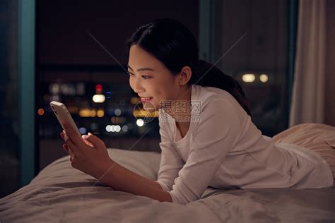 青年女性深夜睡前躺床上玩手机高清图片下载 正版图片501757242 摄图网