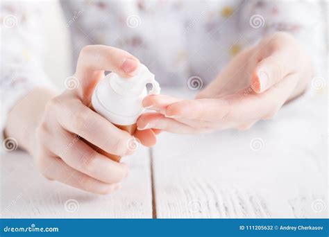 Young Woman Applies Cream On Her Hands On A White Background Stock