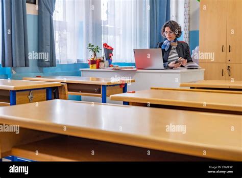 Une Enseignante Mature Crit Des Notes Dans Son Carnet Dans Une Salle De Classe Vide Il Y A
