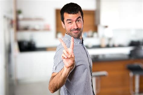 Premium Photo Handsome Man Making Victory Gesture Inside House