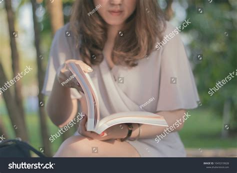 Woman Sitting On Chair And Reading Book With In Garden With Vintage