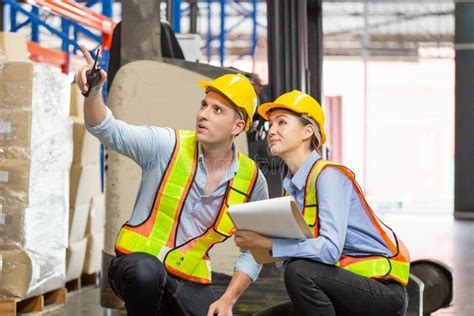 Manager And Supervisor Taking Inventory In Warehouse Foreperson Making