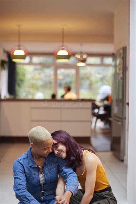 Loving Female Same Sex Couple Cuddling Baby Daughter On Sofa At Home Together Stock Image