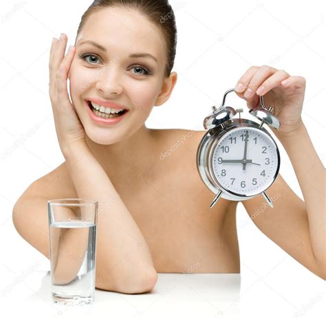 Naked Girl With Glass Of Water Shows Alarm Clock Stock Photo