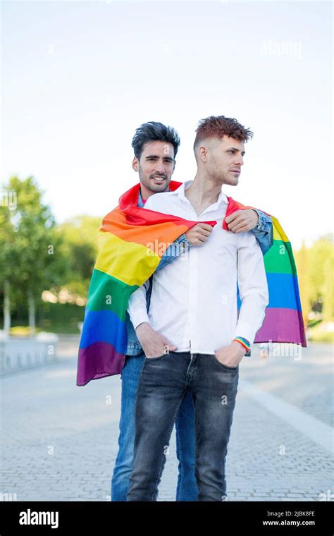 Gay couple embracing with LGBT pride flag outdoors. Relationship ...