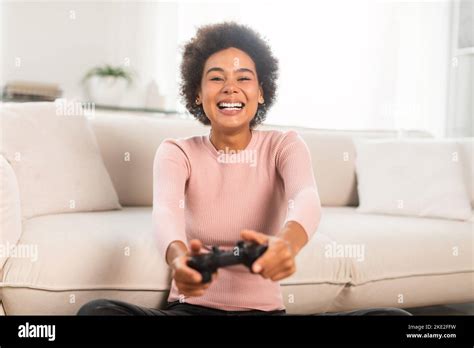 Happy Excited Millennial African American Female With Joystick Sit On